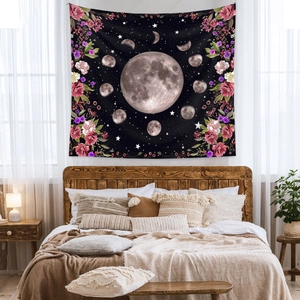 Detailed view of bohemian moon phase tapestry with floral accents over a cozy bed frame