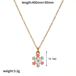 Detailed view of a gold snowflake necklace with white enamel and size specifications