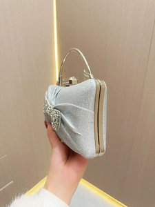 Elegant silver glitter evening clutch bag with rhinestone bow and gold metal handle