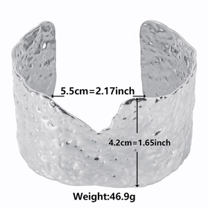 Detailed view of wide silver metal cuff bangle with modern hammered texture and size marks