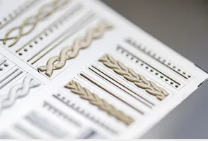 Macro shot of 3D embossed knit texture nail art stickers in gold and silver metallic finish