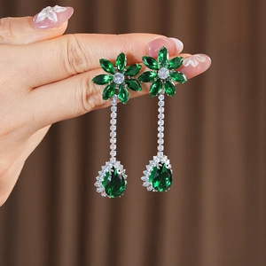 Close-up of emerald floral teardrop earrings with silver setting on a soft background