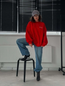 Women's red embroidered letter oversized sweatshirt paired with jeans and boots