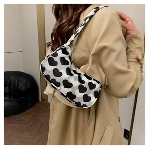 Détail d'un sac à bandoulière chic en toile avec imprimé de motifs coeurs noir et blanc
