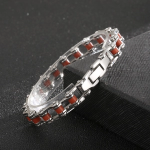 Macro detail of industrial silver and red bicycle chain style stainless steel bracelet