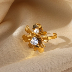 Detail of gold flower ring with pearl stamen and heart-shaped cubic zirconia stone