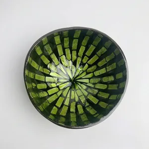 Detail of handmade coconut bowl with green shell mosaic inlay for home decoration
