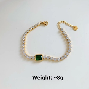 Macro detail of gold-plated stainless steel tennis bracelet with green zircon center stone