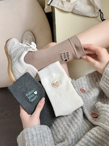 Close-up of cotton socks with embroidered heart patterns and Follow your heart text