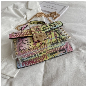 Detail of transparent graffiti jelly bag with gold rivets and metallic chain strap