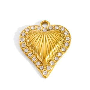 Detail of a 18k gold heart pendant with shell texture and shimmering zircon border