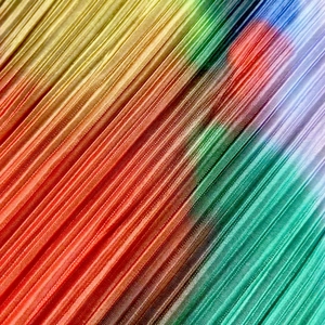 Macro shot of colorful rainbow gradient pleated fabric with vertical accordion texture