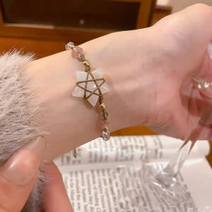 Detailed shot of ethnic beaded bracelet with white star charm and pink crystal stones