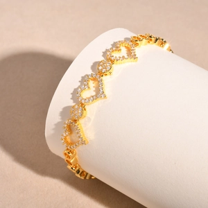 Macro shot of a gold heart-shaped bracelet with cubic zirconia paving on a pedestal