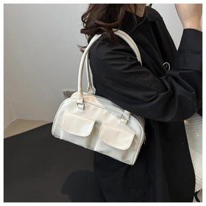 Detail shot of a white minimalist square shoulder bag with dual front flap pockets