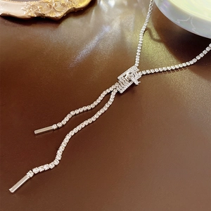 Detail of silver zipper pendant necklace with sparkling cubic zirconia on brown leather