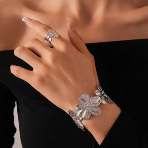 Detail of silver floral textured bangle and ring set with brushed metal finish on model