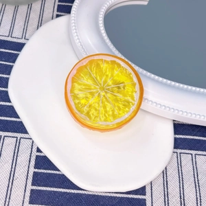 Macro detail of artificial resin orange slice hair clip with realistic pulp texture