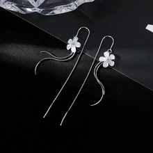 Détail des boucles d'oreilles en argent S925 avec fleur à cinq pétales et glands en perle
