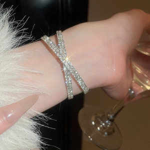 Détail d'un bracelet croisé argenté à double couche orné de zircons cubiques brillants