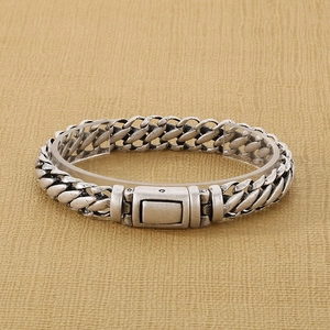 Macro shot of vintage silver-tone titanium steel curb chain bracelet with square clasp