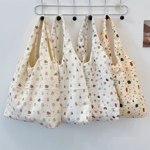 Detail of cute embossed bear patterns on textured bubble fabric shoulder bags