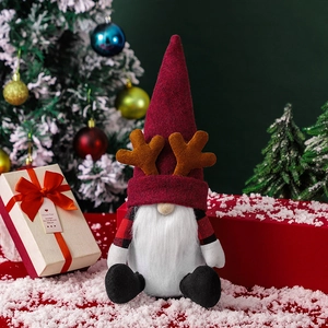 Nordic Christmas gnome doll with reindeer antlers sitting in a festive snow scene decor