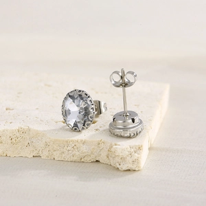 Detailed view of silver rhinestone stud earrings on stone base showing front and back