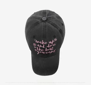 Detail of pink floral embroidery and motivational text on a black washed cotton baseball cap
