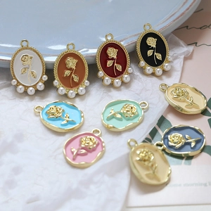 Detailed view of vintage alloy rose charms with colorful enamel and pearl accents