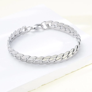 Macro shot of silver men's Cuban chain bracelet featuring high-polished metal links