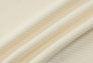 Detailed close-up of cream-colored ribbed knit fabric texture and vertical striped pattern