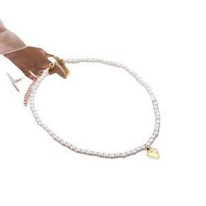 Elegant pearl choker necklace with a gold heart pendant and adjustable lobster clasp