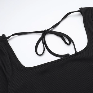 Dettaglio del design con lacci sul collo di questo abito in maglia a coste nero