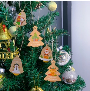 Close-up of kraft paper Christmas ornaments with Santa and deer motifs on tree
