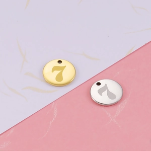 Detailed macro view of 18K gold and silver mirror stainless steel number 7 round pendants