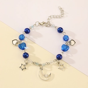 Close-up of blue pearls and heart-shaped charms on a punk star beaded bracelet