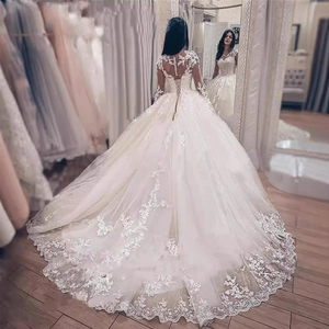 Elegant white lace wedding gown with long sleeves and cathedral train with lace appliqués