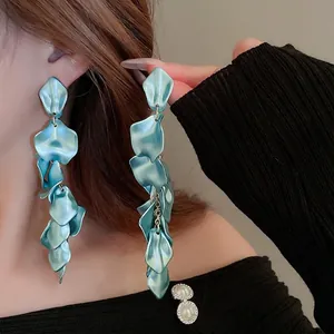 Long light blue petal tassel earrings on model showing elegant layered floral design