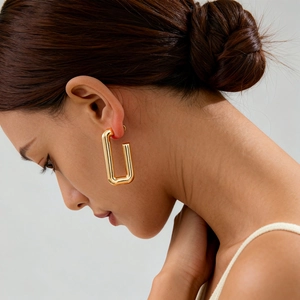 Minimalist gold rectangular metal stud earring shown on a model with glossy finish