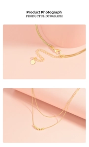 Detail of double-layer gold beaded necklace with lobster clasp and extension chain
