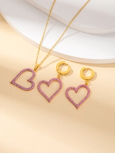 Dettaglio del set di gioielli in titanio con cuori traforati e pavé di cristalli rosa