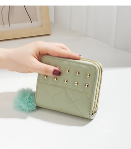 Gros plan du mini porte-monnaie vert menthe avec rivets et double fermeture éclair
