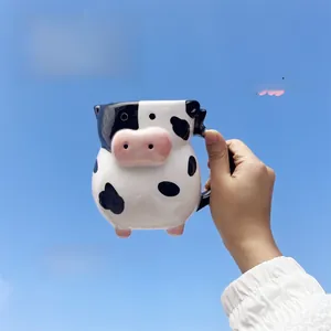 Macro shot of 3D cow-shaped ceramic mug with pink legs against a clear blue sky background