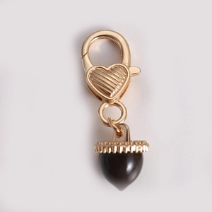 Golden heart-shaped lobster clasp with textured acorn pendant on a white background