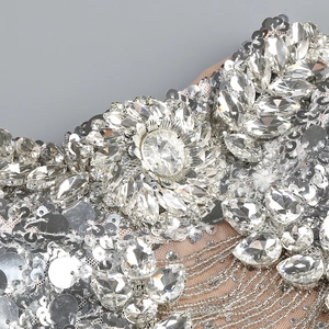 Close-up of sparkling silver sequins and round crystals on sheer mesh evening gown