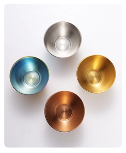 Overhead view of four stainless steel sauce bowls in silver gold rose gold and rainbow