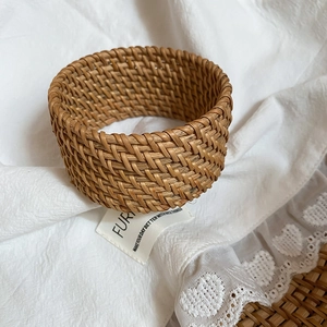 Gros plan d'un bracelet large en rotin tissé à la main avec texture de bois naturelle