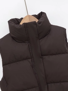 Detail of stand-up collar and quilted texture on a dark brown padded puffer vest