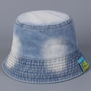 Detail showing acid wash denim bucket hat texture and blue-yellow woven label